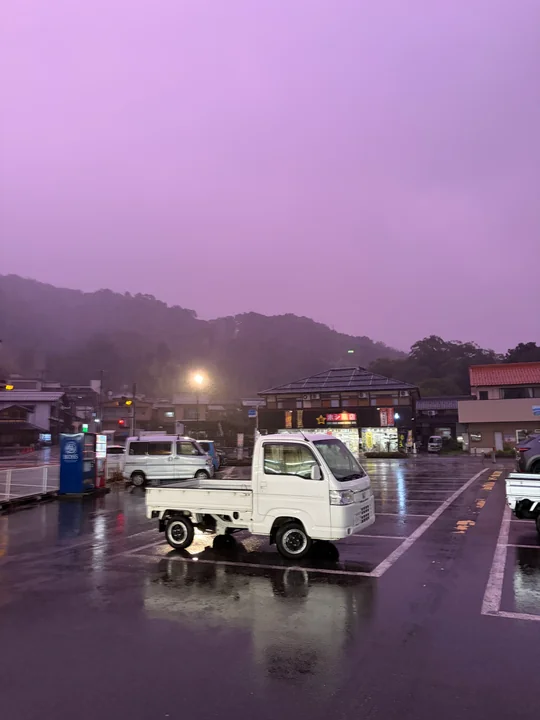 雨に煙る山と濡れた道路